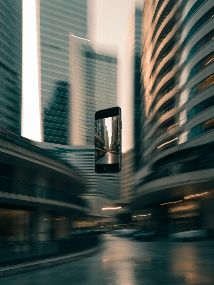 A floating phone brings a city street into focus between motion-blurred towers.